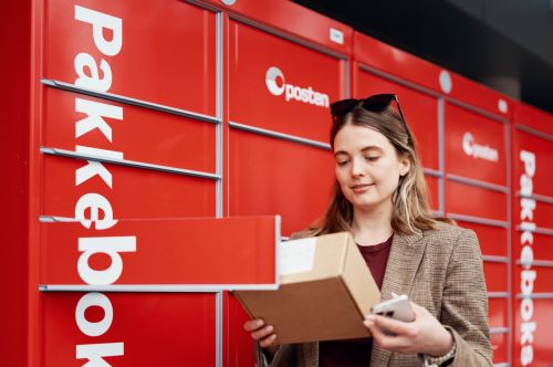 Kvinne henter pakke i pakkeboks