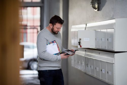 Mann henter reklame i postkassen