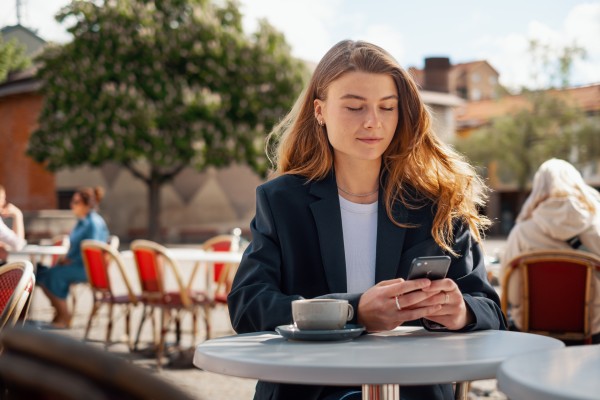 Jente på kafe med mobil