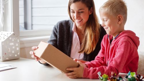 Mother and son opening a parcel by the table