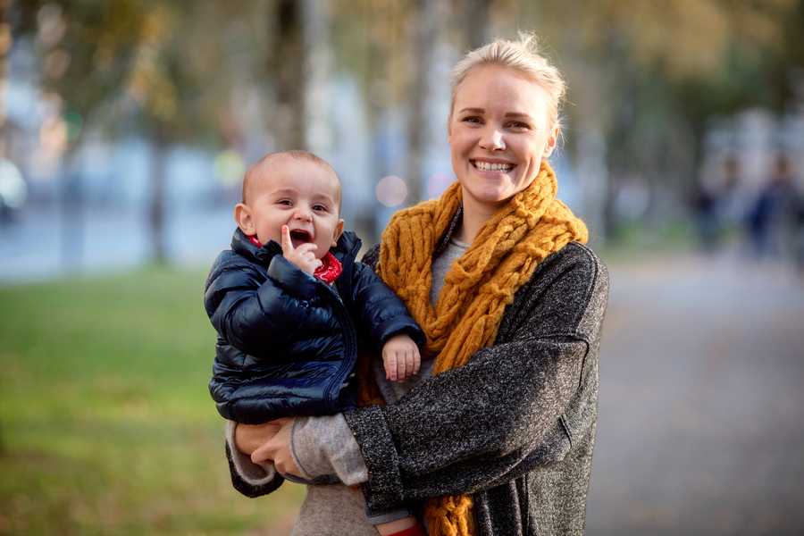 Mother with child on her hip outside in a park