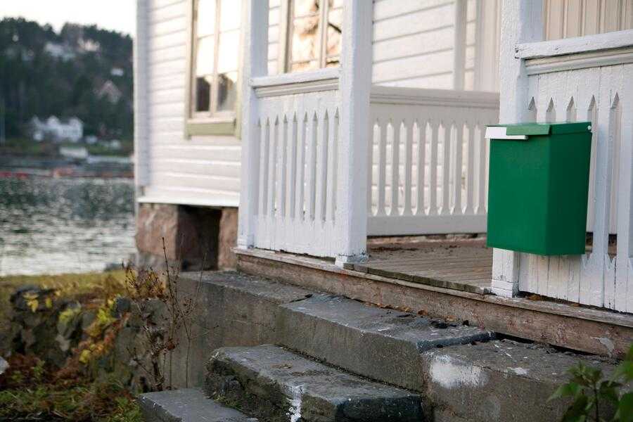 Green mailbox on a white house