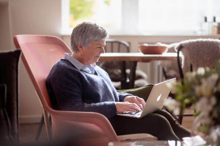 Elderly woman in a chair with laptop