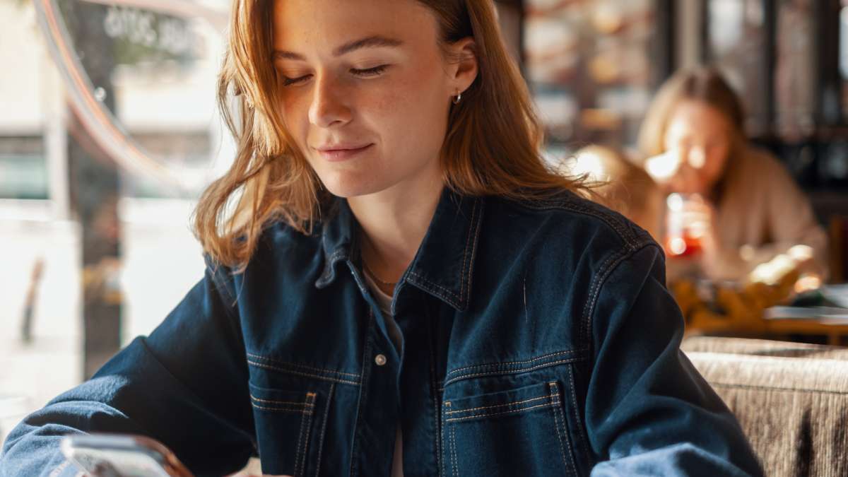 En ung kvinne som ser på mobiltelefonen sin