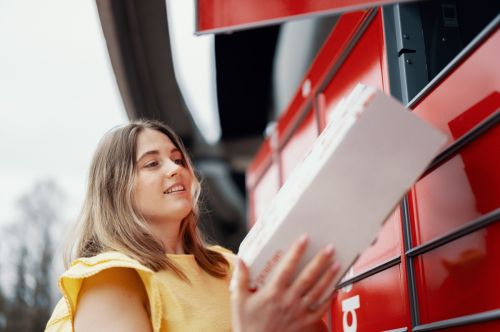 Kvinne henter pakke i pakkeboks